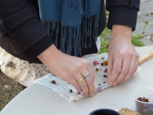 Rolling flowers into silk squares to steam. 